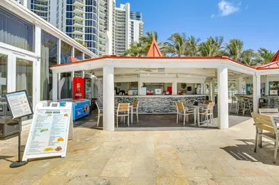 a restaurant with a bar with chairs and tables at Sunny Isles Beach Ocean View Studio with Balcony in Sunny Isles Beach