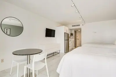 a bedroom with a bed and a table and a mirror at Sunny Isles Beach Ocean View Studio with Balcony in Sunny Isles Beach