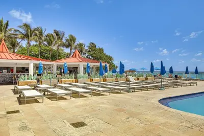a resort with chairs and a swimming pool and a resort at Sunny Isles Beach Ocean View Studio with Balcony in Sunny Isles Beach