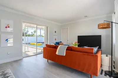 a living room with a couch and a television at Tropical Retreat on Sheridan l Near Beach and Parks in Hollywood