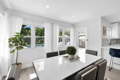 a white dining room with a white table and chairs at Palm Haven in Fort Lauderdale