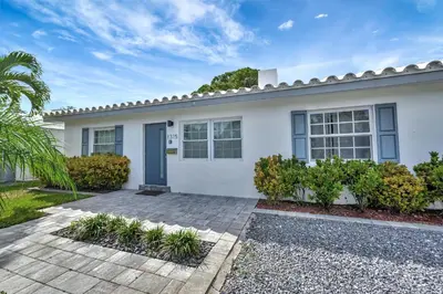 a white house with a blue door at Palm Haven in Fort Lauderdale
