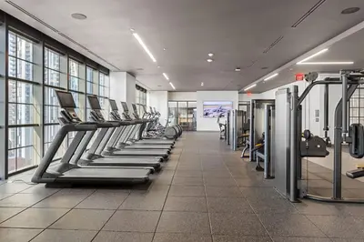 a gym with a row of treadmills and machines at 2002 One bedroom unit for 4 Ppl next to Kaseya Center with Gym and Pool in Downtown Miami in Miami