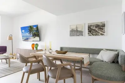 a living room with a couch and a table and chairs at 4513 a 1-Bedroom Apt with Pool and Gym next to Kaseya Center in Miami