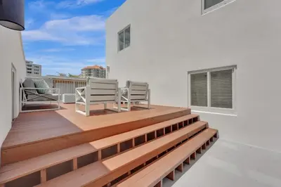a balcony with two chairs and a wooden deck at Eden Collection Studio Steps to Beach in Fort Lauderdale