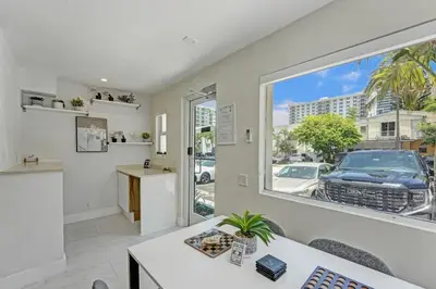 a living room with a white couch and a window at Eden Collection Studio Steps to Beach in Fort Lauderdale