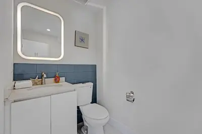 a bathroom with a toilet and a sink and a mirror at Eden Collection Studio Steps to Beach in Fort Lauderdale