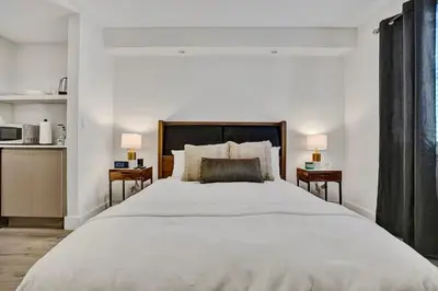 a bedroom with a large white bed with two night stands at Eden Collection Studio Steps to Beach in Fort Lauderdale