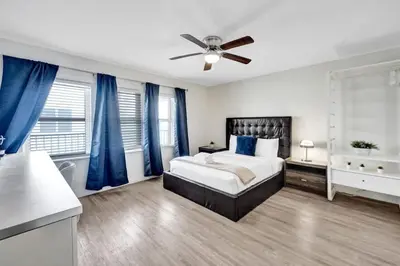 a bedroom with a bed and a ceiling fan at Eden Collection Studio Steps to beach in Fort Lauderdale