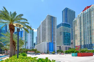 a city skyline with tall buildings and a palm tree at Stylish Brickell Penthouse with Exclusive Perks in Miami