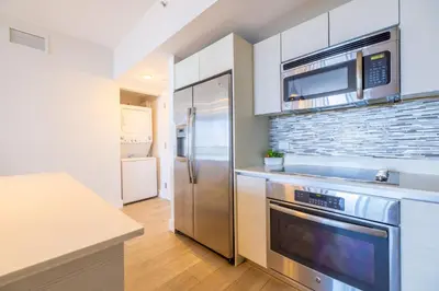 a kitchen with a stainless steel refrigerator and microwave at Coastal Luxe Residences - Premium Suites with Pool and Water Views in Hallandale Beach