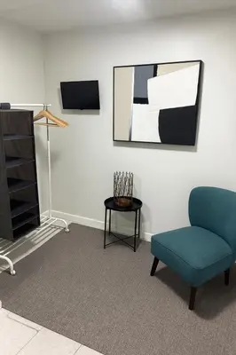 a living room with a chair and a tv at Santamaria Fort Lauderdale Airport in Fort Lauderdale
