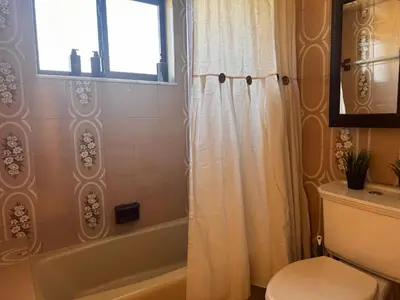 a bathroom with a tub and a toilet and a window at Santamaria Fort Lauderdale Airport in Fort Lauderdale