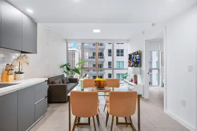 a kitchen and living room with a table and chairs at Modern Comfort by the Beautiful Bay in Miami