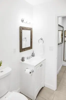 a white bathroom with a sink and a mirror at Buena Vista-Miami Designer Apartment # 3 in Miami