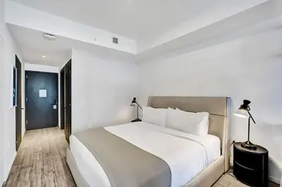 a white bedroom with a large bed and a lamp at Lux Studio Miami and Bay views in Miami