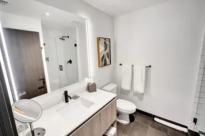 a white bathroom with a sink and a toilet at Lux Studio Miami and Bay views in Miami