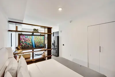 a bedroom with a bed and a flat screen tv at Lux Studio Miami and Bay views in Miami