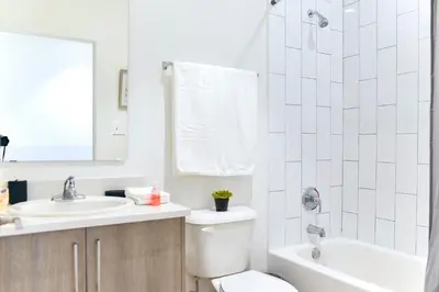 a white bathroom with a toilet and a sink at Family-Friendly Townhouse Getaway Near Top Attractions in Golden Glades