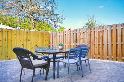 a patio with a table and chairs and a fence at Family-Friendly Townhouse Getaway Near Top Attractions in Golden Glades
