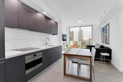 a kitchen with black cabinets and a table in it at Downtown Large Stylish 1 bedroom condo Gym pool in Miami