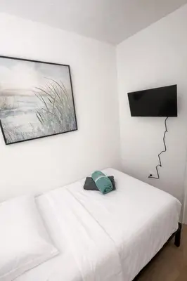 a bedroom with a white bed with a picture on the wall at La Mare Fort Lauderdale Airport in Fort Lauderdale