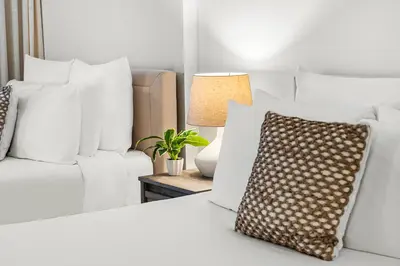a white bedroom with white pillows and a couch at Studio Residence at Roney -1128 in Miami Beach