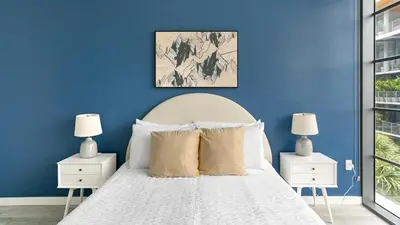 a blue bedroom with a white bed with two night stands at The Juliet IV Vibe 8697 in Miami