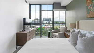 a bedroom with a bed and a television and a chair at The Juliet V Vibe 8700 in Miami
