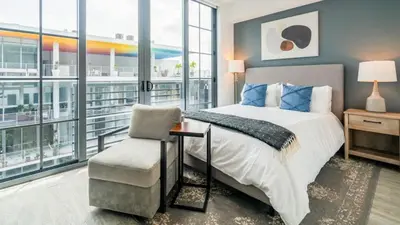 a bedroom with a bed and a chair and windows at The Juliet IX Vibe 8707 in Miami