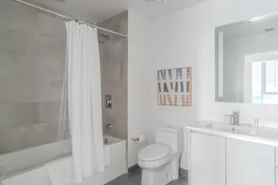 a white bathroom with a toilet and a tub and a sink at The Juliet XI Vibe 8744 in Miami
