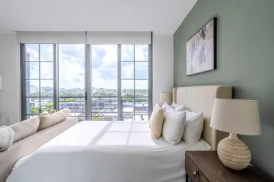 a bedroom with a large white bed with windows at The Juliet XII Vibe 8745 in Miami