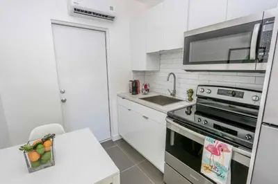 a kitchen with a sink and a stove top oven at Mimo Bungalows By Renzzi in Miami