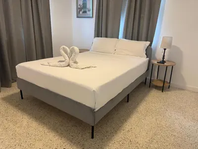a bedroom with a bed with white sheets and pillows at Wynwood Bungalows By Renzzi in Miami
