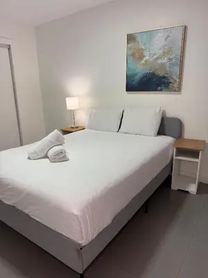 a bedroom with a large white bed with a lamp on it at Wynwood Bungalows By Renzzi in Miami