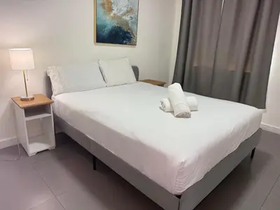 a bed with white sheets and pillows in a bedroom at Wynwood Bungalows By Renzzi in Miami