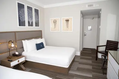 a bedroom with a bed and a table and a chair at San Juan Hotel Miami Beach in Miami Beach