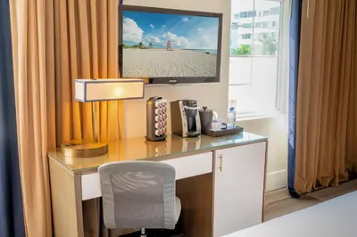 a hotel room with a desk with a television on it at San Juan Hotel Miami Beach in Miami Beach