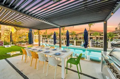 a white table and chairs on a patio with a pool at Waterfront Heated pool Lime Key Two in Fort Lauderdale