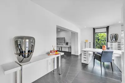 a white living room with a table and a vase at Family Vacation Home in Miami