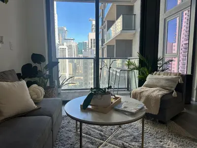 a living room with a couch and a table and a large window at Luxe Ventures Miami in Miami