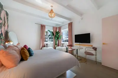 a bedroom with a white bed and a tv at Le Particulier Miami in Miami Beach