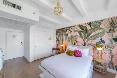 a bedroom with a white bed with a tropical wallpaper at Le Particulier Miami in Miami Beach