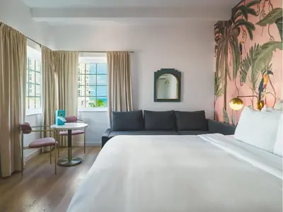 a bedroom with a large bed and a couch at Le Particulier Miami in Miami Beach