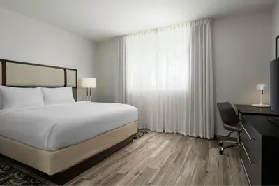 a bedroom with a bed and a desk and a window at Residence Inn by Marriott Miami Beach Surfside in Miami Beach