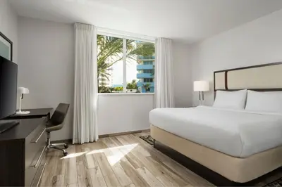 a white bedroom with a bed and a window at Residence Inn by Marriott Miami Beach Surfside in Miami Beach