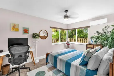 a bedroom with a bed and a desk and a window at The Frolics -Stunning Wilton Manors Pool Home in Fort Lauderdale