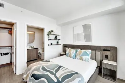 a bedroom with a large bed and a bathroom at 72 Park by Nomada Residences in Miami Beach
