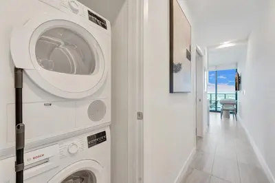 a laundry room with a washer and dryer next to a hallway at 72 Park by Nomada Residences in Miami Beach