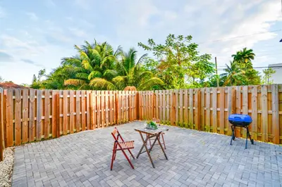 two chairs and a table in front of a wooden fence at Family Comfort Near Top Spots-Relaxing Stay for Everyone in Golden Glades